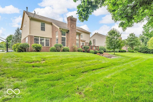 5865 Osage Dr, Carmel, IN 46033 - back of house with brick siding, a chimney, a yard, and a wooden deck