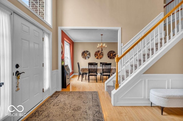 5865 Osage Dr, Carmel, IN 46033 - foyer entrance featuring stairs, healthy amount of natural light, wainscoting, hardwood / wood-style floors, and a chandelier