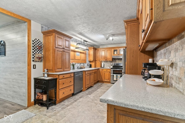 5110 W County Road 400 N, Scipio, IN 47273 - kitchen with appliances with stainless steel finishes, brown cabinets, a textured ceiling, tasteful backsplash, and under cabinet range hood