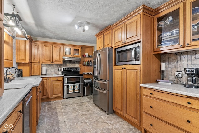 5110 W County Road 400 N, Scipio, IN 47273 - kitchen featuring appliances with stainless steel finishes, under cabinet range hood, brown cabinets, decorative backsplash, and a textured ceiling