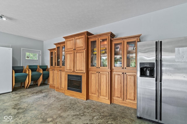 5110 W County Road 400 N, Scipio, IN 47273 - kitchen with stainless steel refrigerator with ice dispenser, freestanding refrigerator, brown cabinetry, glass insert cabinets, and a textured ceiling