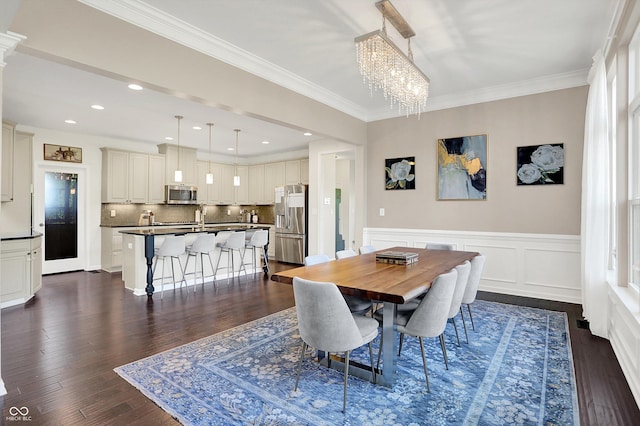 16711 Meadow Wood Dr, Noblesville, IN 46062 - dining room with a chandelier, dark wood-style floors, ornamental molding, a wainscoted wall, and recessed lighting
