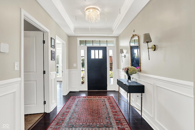 16711 Meadow Wood Dr, Noblesville, IN 46062 - foyer entrance featuring a decorative wall, a tray ceiling, dark wood finished floors, wainscoting, and a chandelier
