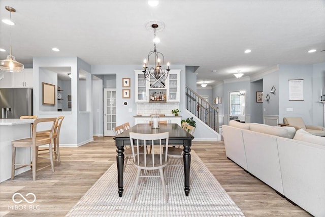 5542 Pennycress Dr, Noblesville, IN 46062 - dining room featuring stairway, light wood-type flooring, a chandelier, recessed lighting, and crown molding