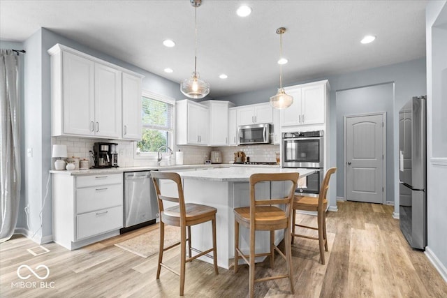 5542 Pennycress Dr, Noblesville, IN 46062 - kitchen featuring stainless steel appliances, light wood-style flooring, white cabinets, and recessed lighting