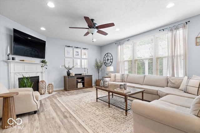 5542 Pennycress Dr, Noblesville, IN 46062 - living area with light wood-type flooring, recessed lighting, a ceiling fan, a premium fireplace, and a textured ceiling