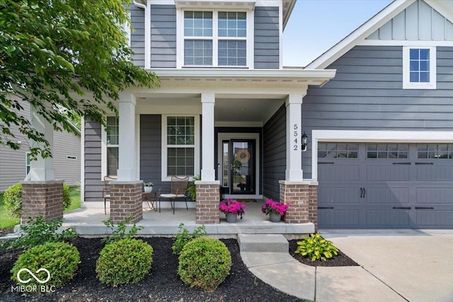 5542 Pennycress Dr, Noblesville, IN 46062 - view of exterior entry featuring covered porch, a garage, concrete driveway, and board and batten siding