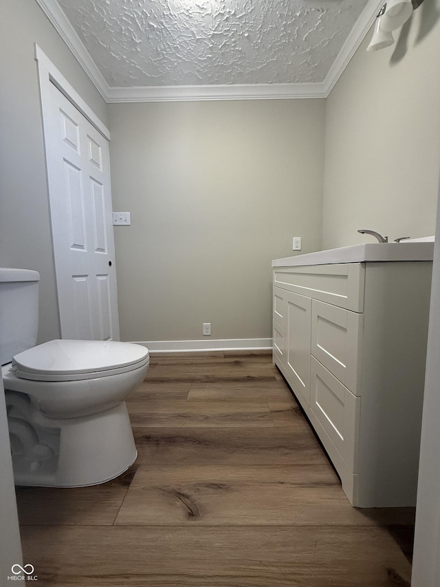 131 S Beatty St, Columbus, IN 47201 - bathroom featuring wood finished floors, a textured ceiling, vanity, and crown molding
