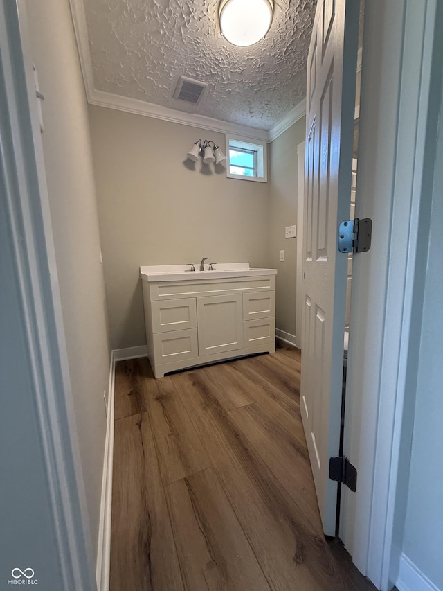 131 S Beatty St, Columbus, IN 47201 - bathroom with wood finished floors, crown molding, and vanity