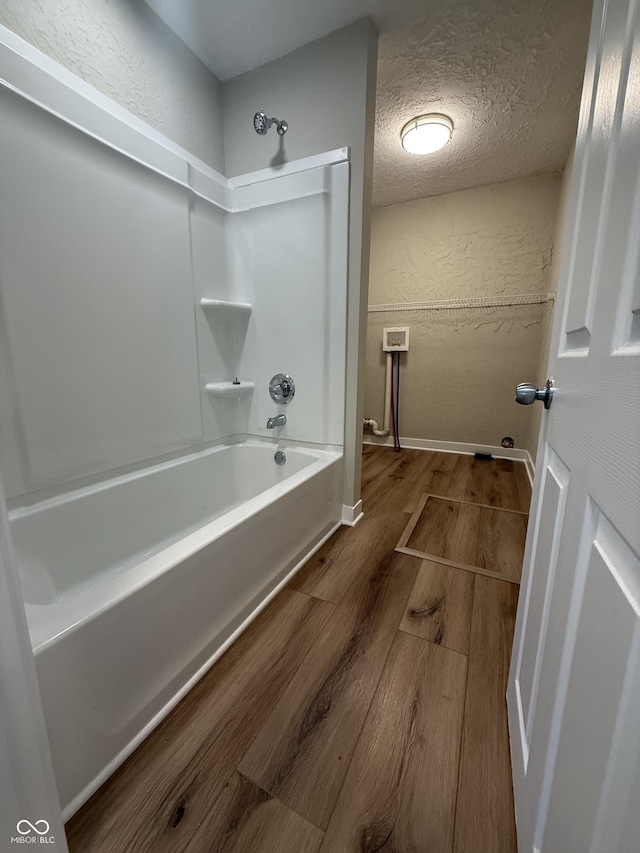 131 S Beatty St, Columbus, IN 47201 - full bath with wood finished floors, a textured wall, and shower / bath combination