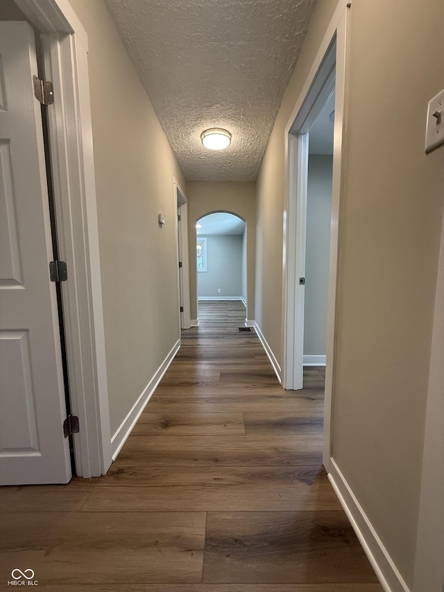 131 S Beatty St, Columbus, IN 47201 - hall with arched walkways, dark wood-type flooring, and a textured ceiling