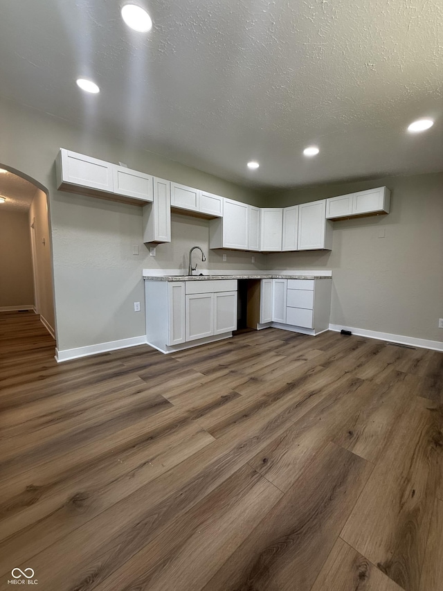 131 S Beatty St, Columbus, IN 47201 - kitchen featuring white cabinets, dark wood finished floors, arched walkways, recessed lighting, and a textured ceiling