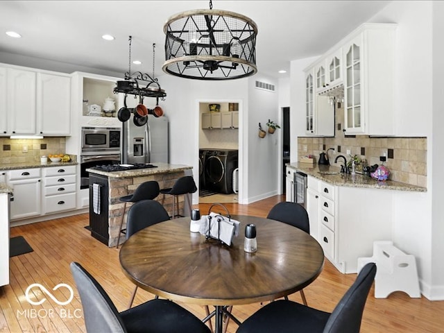 4233 Dartmoor Dr, Greenwood, IN 46143 - dining space featuring independent washer and dryer, light wood-type flooring, and recessed lighting