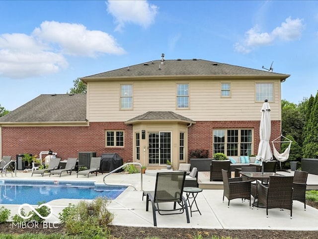 4233 Dartmoor Dr, Greenwood, IN 46143 - back of property with brick siding, outdoor lounge area, a patio, and an outdoor pool
