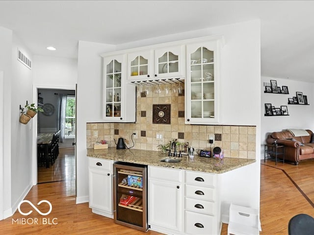 4233 Dartmoor Dr, Greenwood, IN 46143 - indoor wet bar with wine cooler, light wood-style floors, backsplash, and recessed lighting