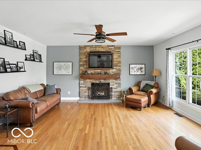 4233 Dartmoor Dr, Greenwood, IN 46143 - living area with wood finished floors, a ceiling fan, and a stone fireplace