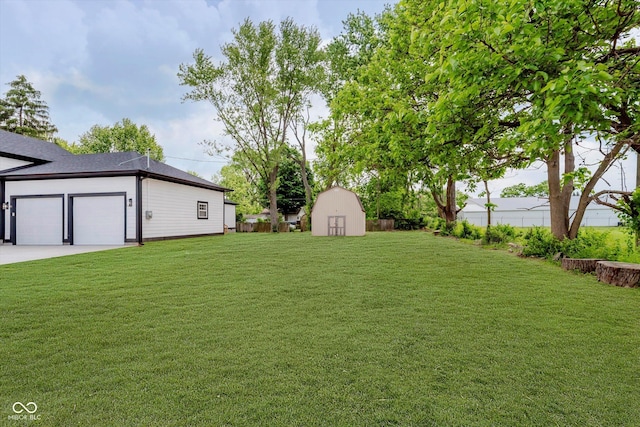 2125 N Pasadena St, Indianapolis, IN 46219 - view of yard with a shed, an attached garage, and driveway