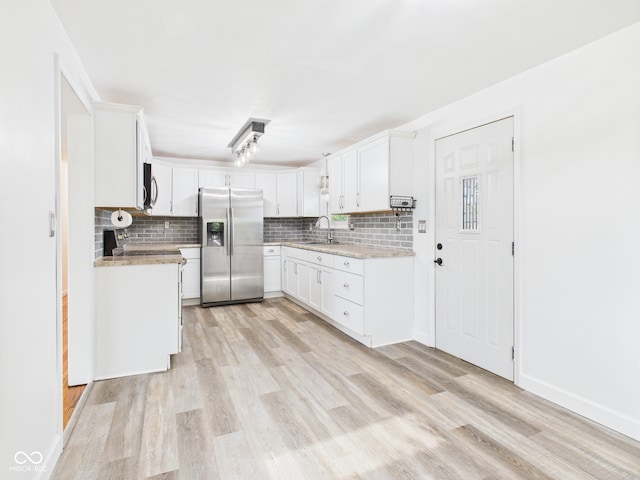 203 Plum St E, Frankton, IN 46044 - kitchen featuring stainless steel appliances, decorative backsplash, light wood finished floors, and white cabinets