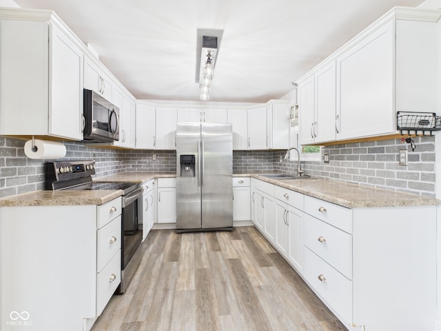 203 Plum St E, Frankton, IN 46044 - kitchen featuring stainless steel appliances, decorative backsplash, light wood-type flooring, and white cabinets