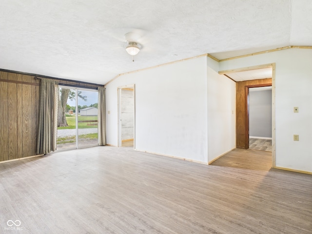 203 Plum St E, Frankton, IN 46044 - unfurnished room with vaulted ceiling, wood finished floors, and a textured ceiling