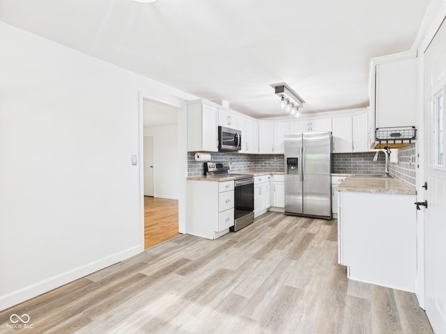 203 Plum St E, Frankton, IN 46044 - kitchen featuring stainless steel appliances, backsplash, light wood-style floors, and white cabinets