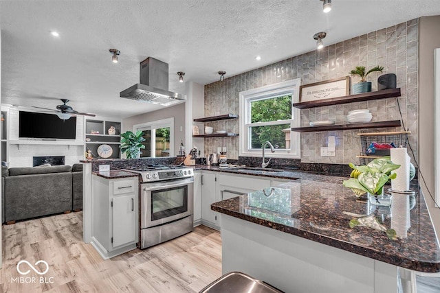 7502 Colony Cir, Indianapolis, IN 46260 - kitchen with gas stove, wall chimney range hood, open shelves, a peninsula, and a textured ceiling