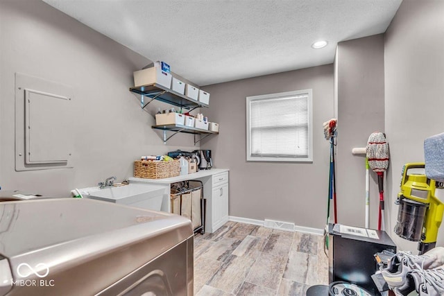 7502 Colony Cir, Indianapolis, IN 46260 - laundry area with electric panel, a textured ceiling, recessed lighting, light wood finished floors, and separate washer and dryer