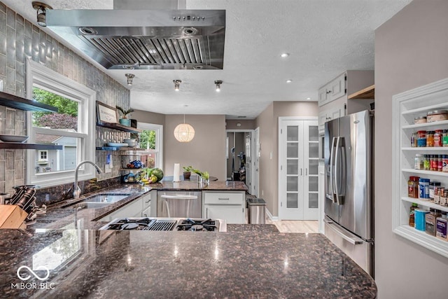 7502 Colony Cir, Indianapolis, IN 46260 - kitchen with stainless steel appliances, open shelves, wall chimney exhaust hood, a peninsula, and a textured ceiling