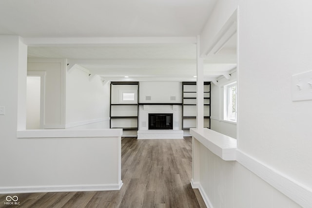 5134 Rinehart Ave, Indianapolis, IN 46241 - unfurnished living room with wood finished floors, a glass covered fireplace, and beamed ceiling