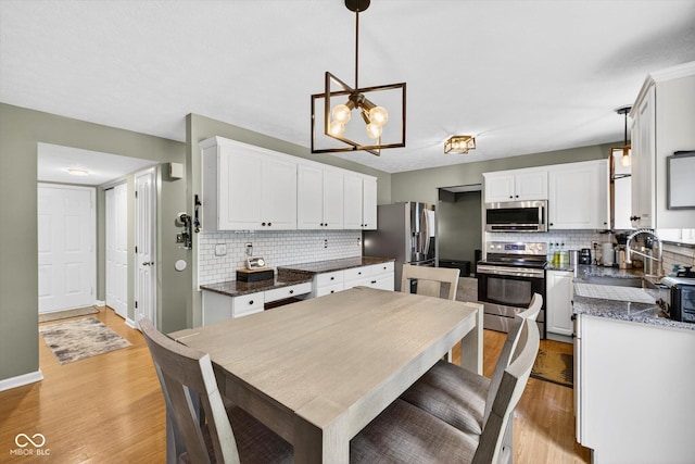 13470 Shakamac Dr, Carmel, IN 46032 - kitchen featuring stainless steel appliances, decorative backsplash, white cabinets, and light wood-type flooring