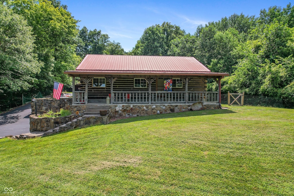 1324 S County Road 740 W, Medora, IN 47260 - view of front of house featuring covered porch, a metal roof, and log siding
