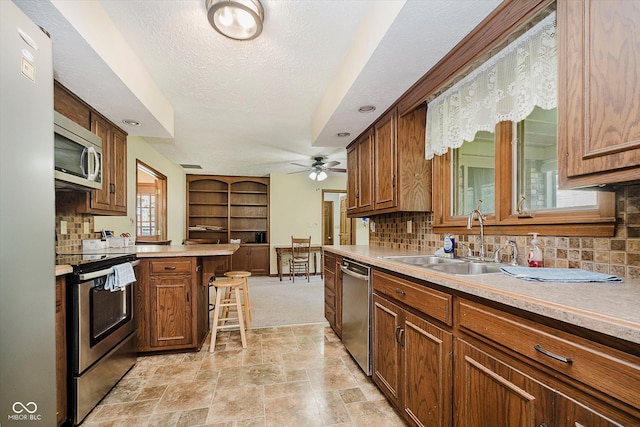 450 W 250 N, Lebanon, IN 46052 - kitchen featuring appliances with stainless steel finishes, decorative backsplash, light stone finish floors, ceiling fan, and a textured ceiling