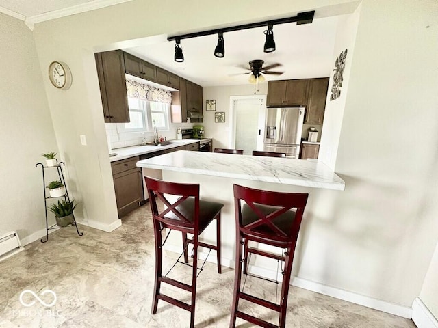 1076 N Old Highway 27, Winchester, IN 47394 - kitchen featuring appliances with stainless steel finishes, a peninsula, dark brown cabinets, crown molding, and ceiling fan