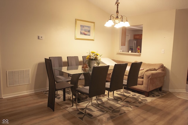 291 Lakemoore St, Brownsburg, IN 46112 - dining area with wood finished floors, a chandelier, and vaulted ceiling