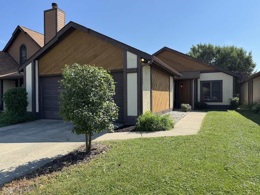 4049 Zinfandel Way, Indianapolis, IN 46254 - view of front of property with an attached garage, a chimney, a front yard, and driveway