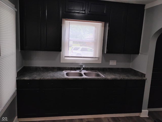 94 N Routiers Ave, Indianapolis, IN 46219 - kitchen with dark cabinetry, dark countertops, and arched walkways
