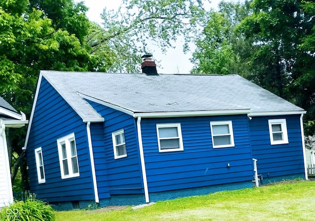 94 N Routiers Ave, Indianapolis, IN 46219 - view of property exterior featuring a chimney, a yard, and a shingled roof