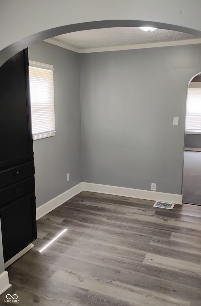 94 N Routiers Ave, Indianapolis, IN 46219 - unfurnished room featuring arched walkways, wood finished floors, and crown molding
