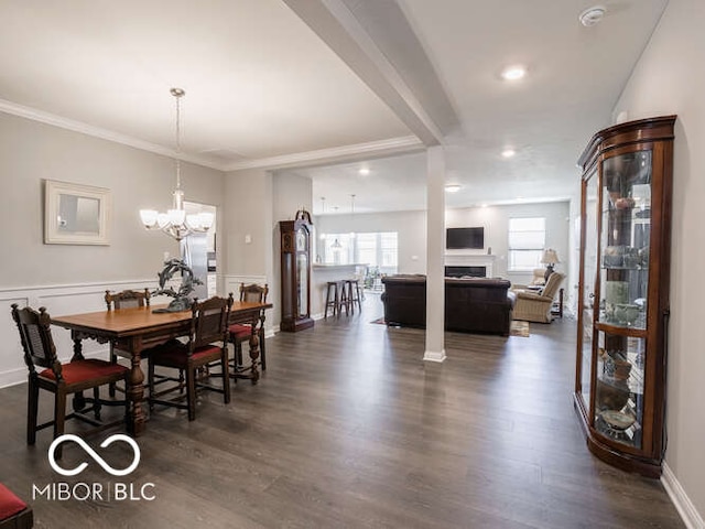 8866 Twain Ln, Indianapolis, IN 46239 - dining room featuring healthy amount of natural light, dark wood-style flooring, a chandelier, a fireplace, and crown molding