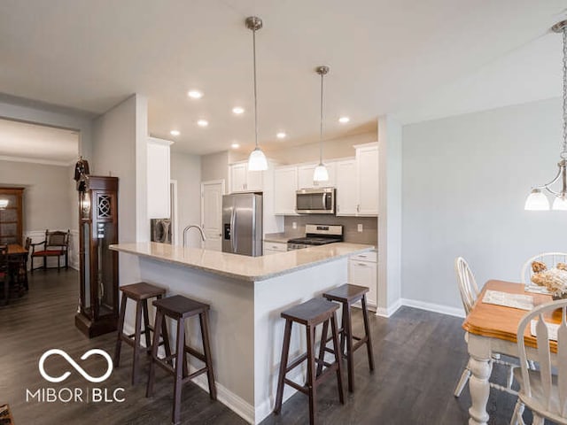 8866 Twain Ln, Indianapolis, IN 46239 - kitchen featuring stainless steel appliances, dark wood-style flooring, a kitchen breakfast bar, a peninsula, and recessed lighting