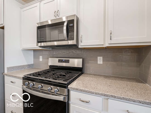 8866 Twain Ln, Indianapolis, IN 46239 - kitchen featuring appliances with stainless steel finishes, white cabinets, tasteful backsplash, and light stone countertops