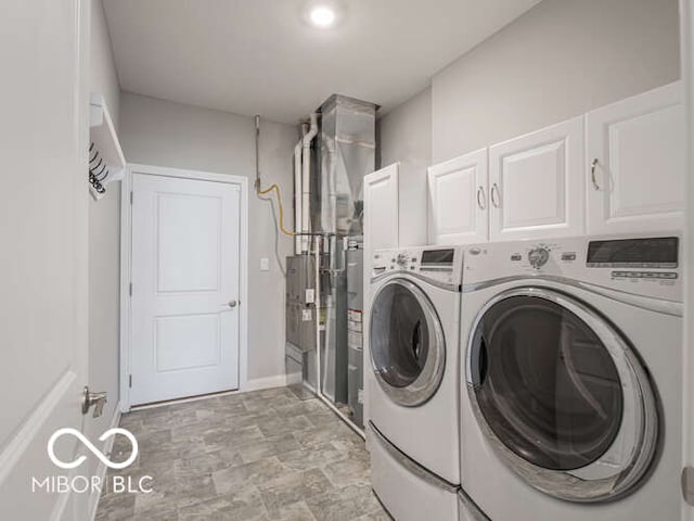 8866 Twain Ln, Indianapolis, IN 46239 - laundry room featuring cabinet space, washer and dryer, and stone finish floors