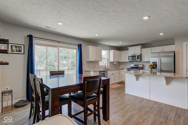 2500 Sand Hollow Dr, Lebanon, IN 46052 - dining space featuring light wood-type flooring, a textured ceiling, and recessed lighting