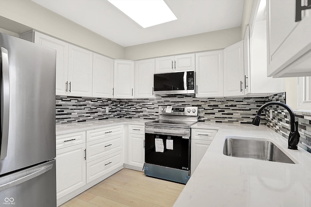 5015 Nowland Ave, Indianapolis, IN 46201 - kitchen featuring appliances with stainless steel finishes, white cabinetry, and tasteful backsplash