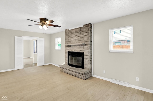 5015 Nowland Ave, Indianapolis, IN 46201 - unfurnished living room featuring a ceiling fan, a textured ceiling, a fireplace, and wood finished floors