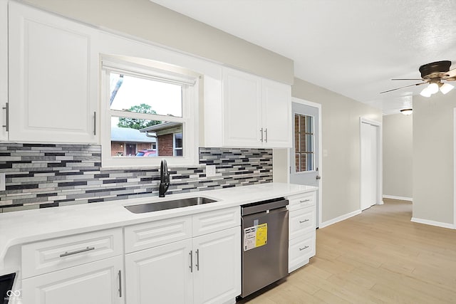 5015 Nowland Ave, Indianapolis, IN 46201 - kitchen with stainless steel dishwasher, backsplash, light countertops, and white cabinets