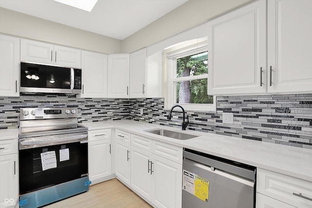 5015 Nowland Ave, Indianapolis, IN 46201 - kitchen with appliances with stainless steel finishes, light countertops, decorative backsplash, and white cabinetry