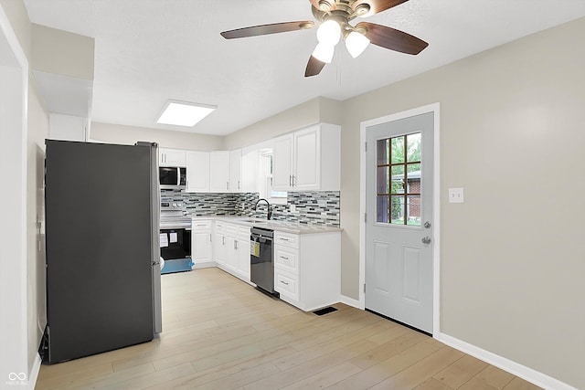 5015 Nowland Ave, Indianapolis, IN 46201 - kitchen featuring stainless steel appliances, light countertops, backsplash, a ceiling fan, and light wood-type flooring