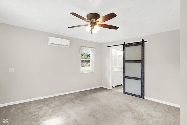 5015 Nowland Ave, Indianapolis, IN 46201 - spare room featuring a wall unit AC, a ceiling fan, carpet flooring, a barn door, and a textured ceiling