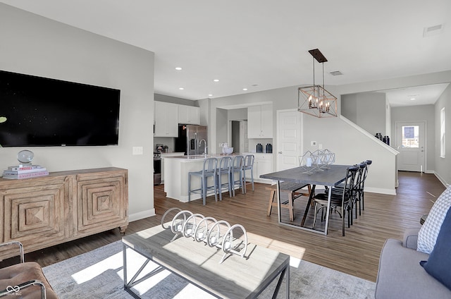 7687 Marin Pkwy, Cumberland, IN 46229 - living room featuring wood finished floors, a chandelier, stairway, and recessed lighting